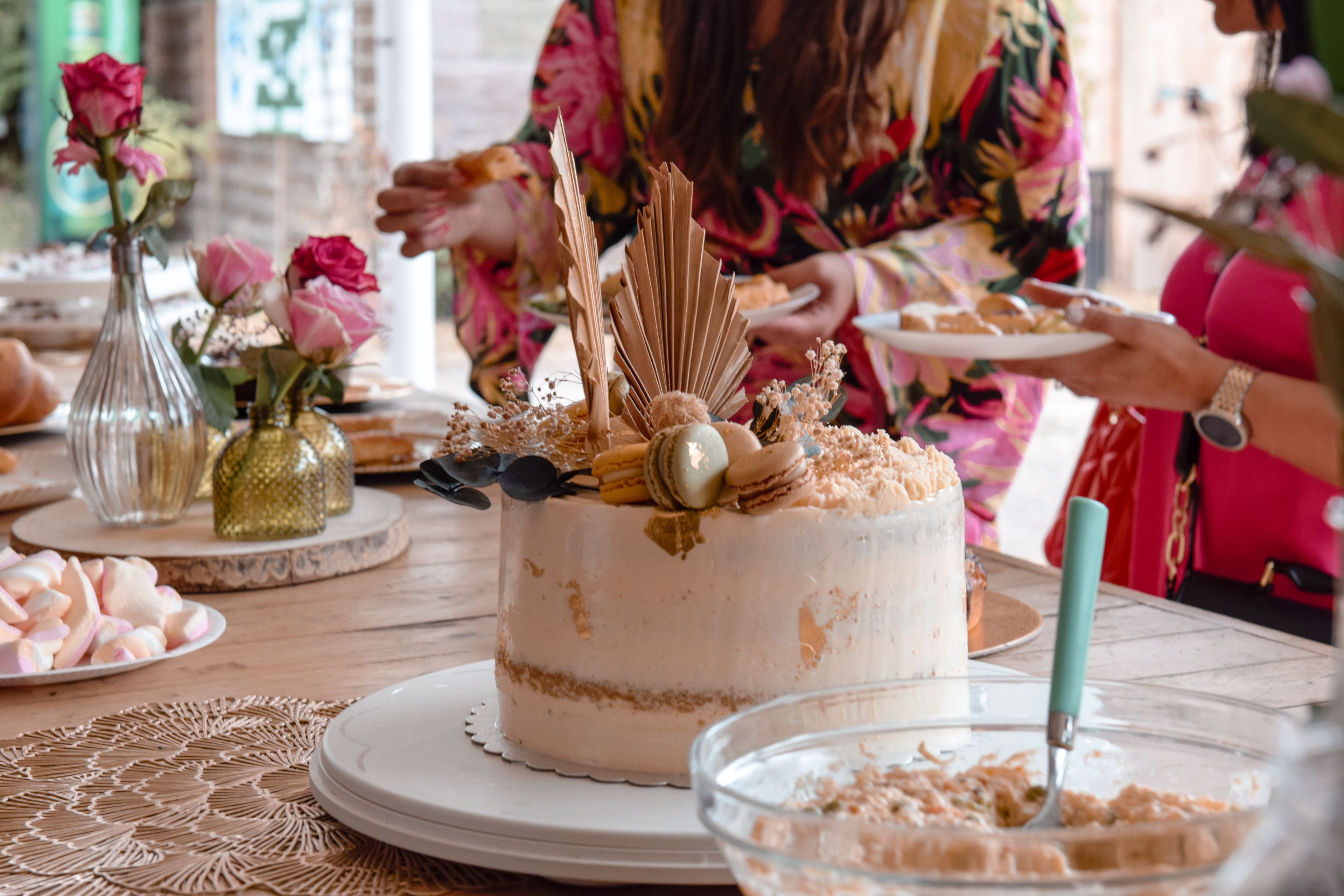 Auf dem Bild ist eine originell verzierte Torte dargestellt auf einem Tisch mit weiterem Backwerk und Süßigkeiten.