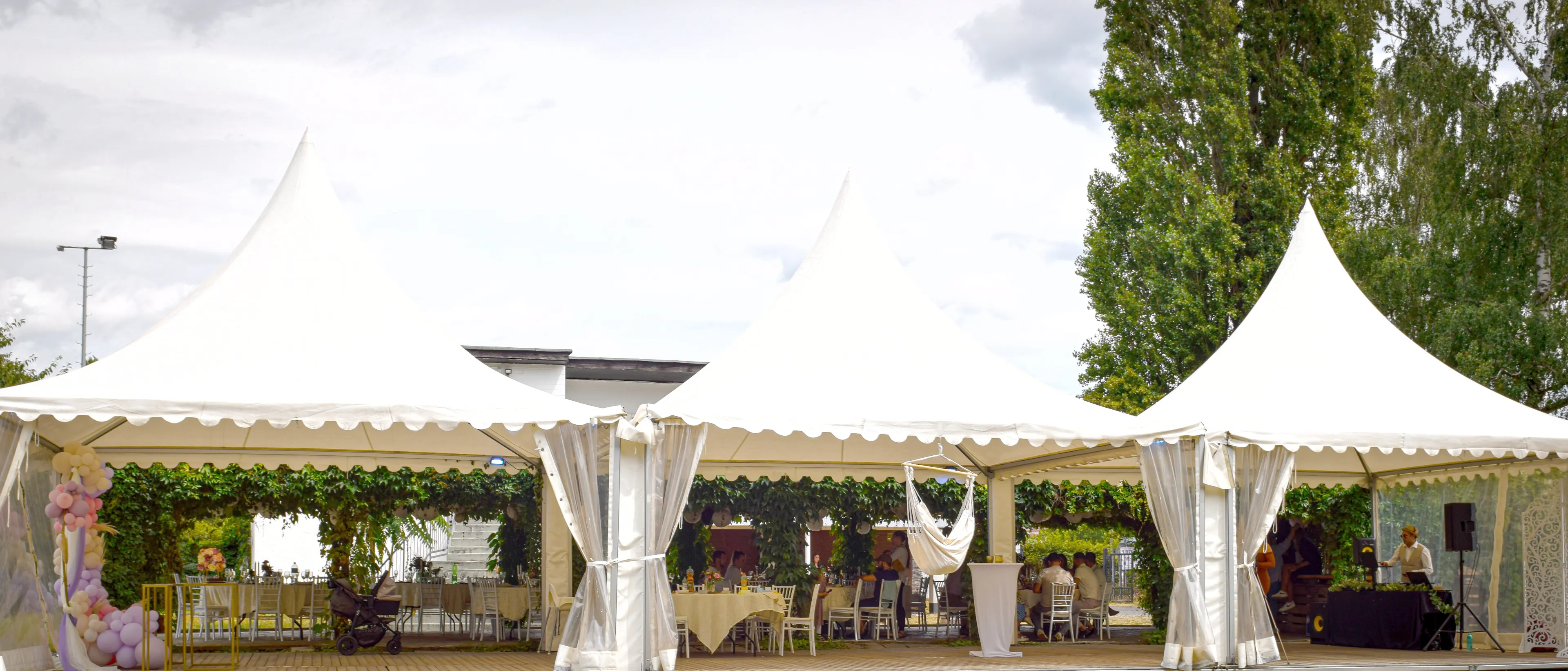 Das Bild zeigt die Ansicht vom aus auf die drei Zelte und dahinter den Pavillion