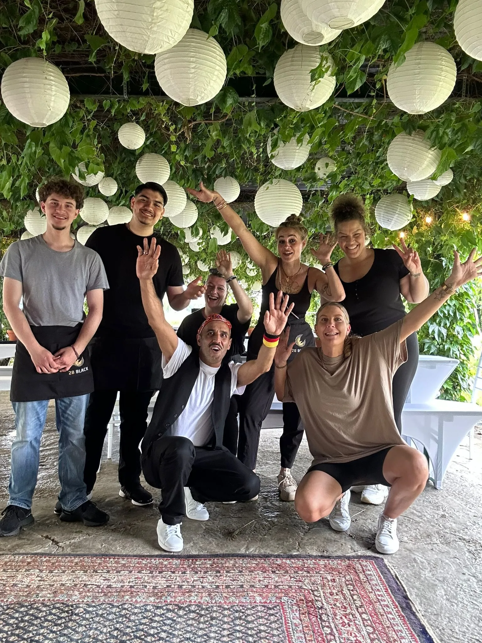 Es wird hier eine Feiergesellschaft gezeigt, die an festlich gedeckten Tischen sitzt und sich unterhält